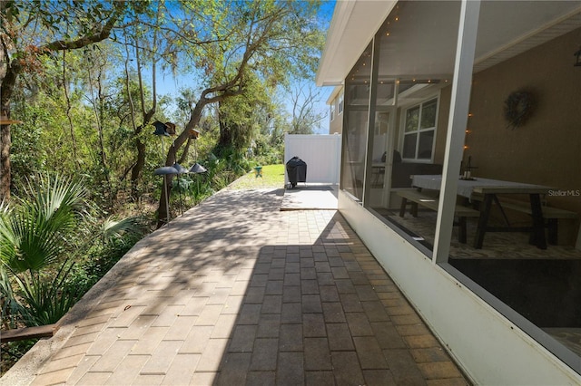 view of patio / terrace with a sunroom and fence