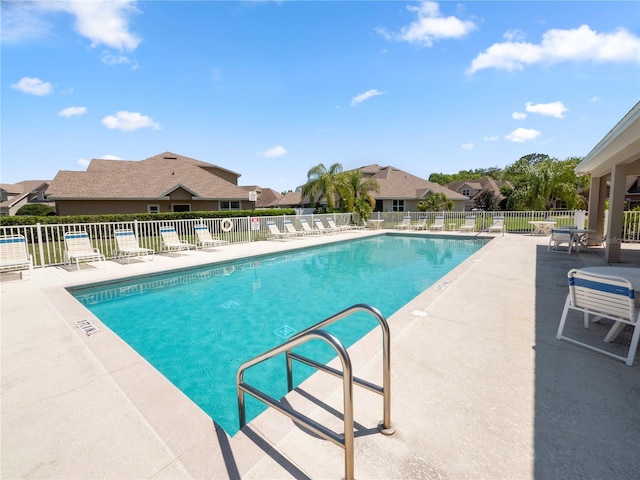 pool featuring a patio, fence, and a residential view