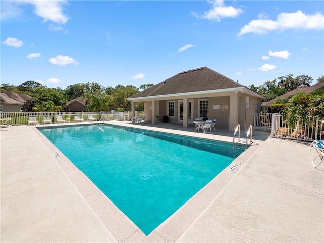 community pool with fence and a patio