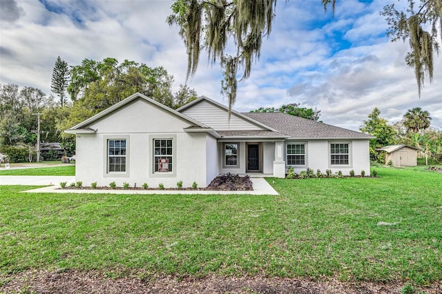 ranch-style home featuring stucco siding, a storage shed, an outdoor structure, and a front yard