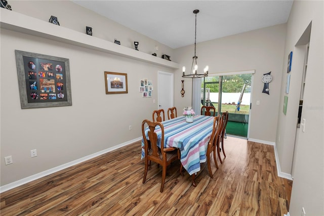 dining room with a notable chandelier, baseboards, and wood finished floors