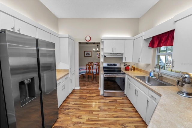 kitchen featuring light countertops, appliances with stainless steel finishes, white cabinets, a sink, and under cabinet range hood