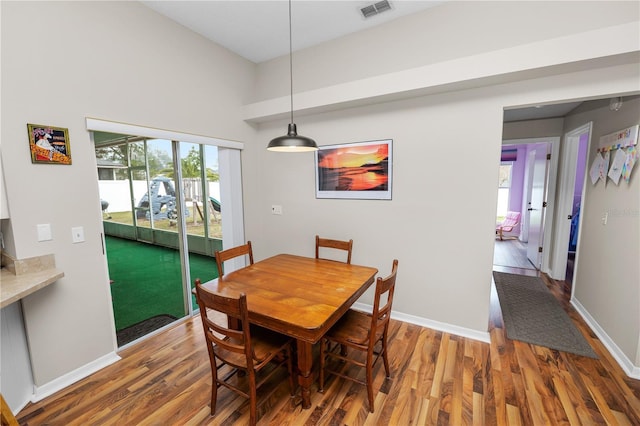 dining room with baseboards, visible vents, and wood finished floors