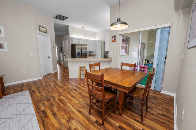 dining area with baseboards, visible vents, and wood finished floors