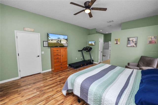 bedroom featuring visible vents, ceiling fan, a textured ceiling, wood finished floors, and baseboards