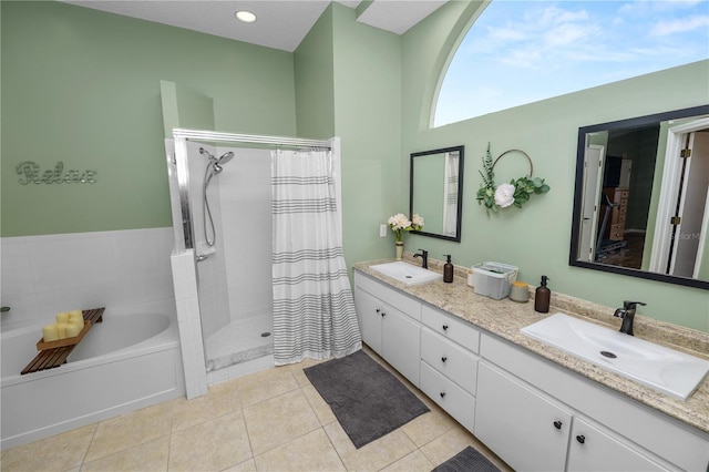 bathroom with a garden tub, a stall shower, a sink, and tile patterned floors