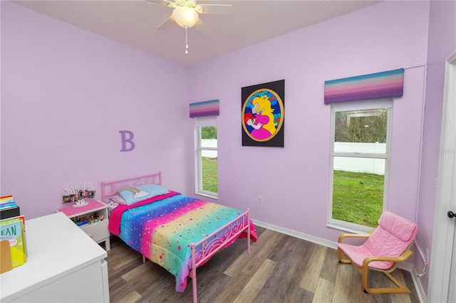 bedroom with a ceiling fan, baseboards, and wood finished floors