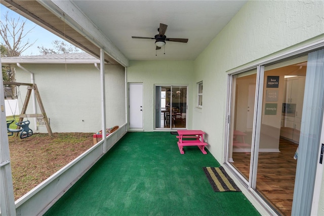 unfurnished sunroom featuring a ceiling fan