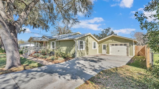 ranch-style home with a garage, driveway, a porch, and fence