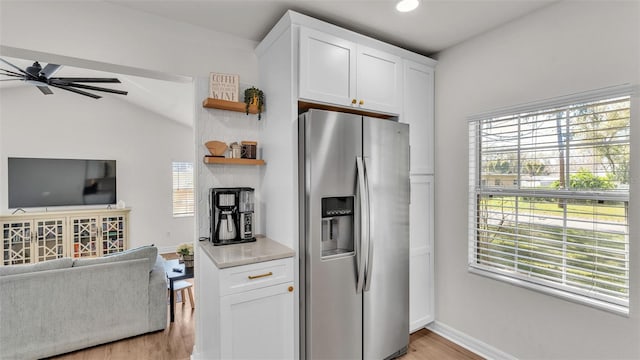 kitchen featuring white cabinetry, open floor plan, light countertops, stainless steel fridge with ice dispenser, and open shelves