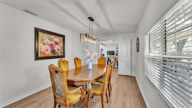 dining area featuring light wood-type flooring, baseboards, and visible vents