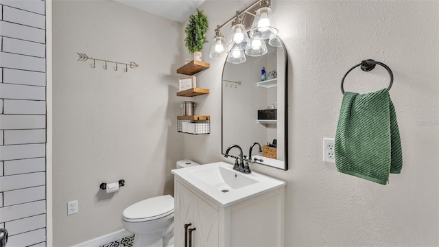 bathroom featuring toilet, baseboards, and vanity