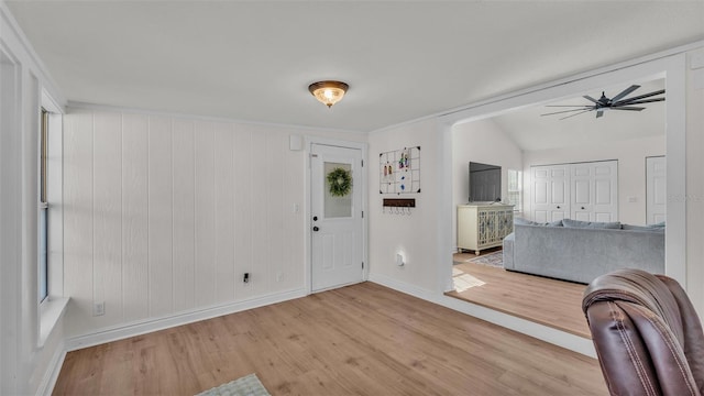 entrance foyer with lofted ceiling, ceiling fan, light wood-style flooring, and baseboards