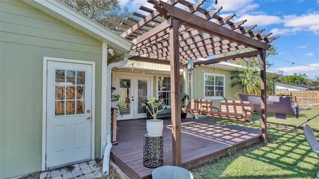 wooden terrace featuring a lawn, fence, a pergola, and french doors