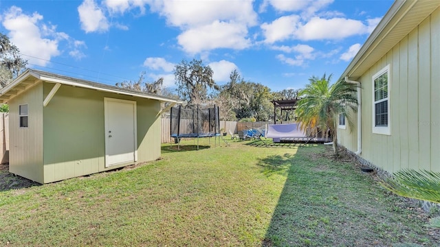 view of yard with a storage shed, a trampoline, fence, an outdoor structure, and a pergola