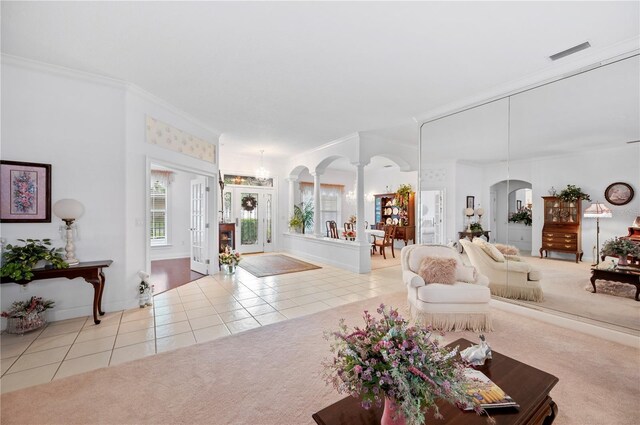 tiled living area featuring arched walkways, decorative columns, carpet flooring, and visible vents