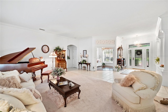 living area with arched walkways, light colored carpet, an inviting chandelier, ornamental molding, and light tile patterned flooring