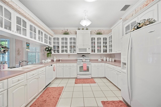 kitchen featuring light tile patterned floors, white appliances, a sink, visible vents, and ornamental molding