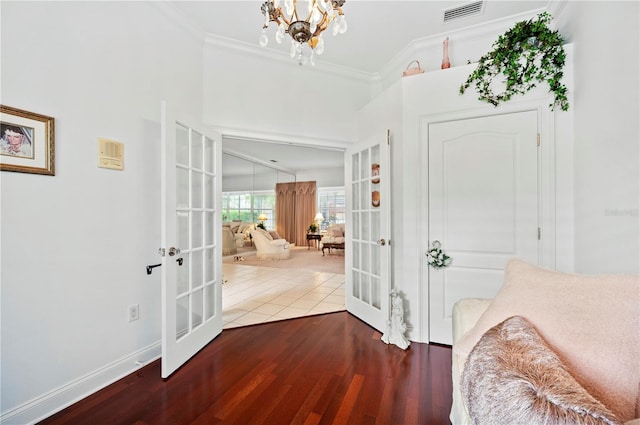 interior space featuring ornamental molding, french doors, wood finished floors, and visible vents