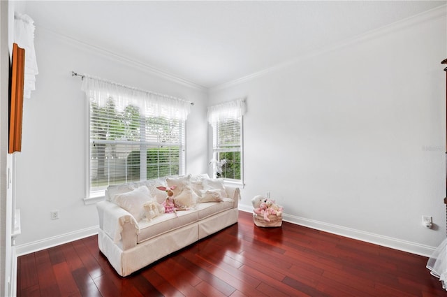 living area with wood-type flooring, baseboards, and crown molding