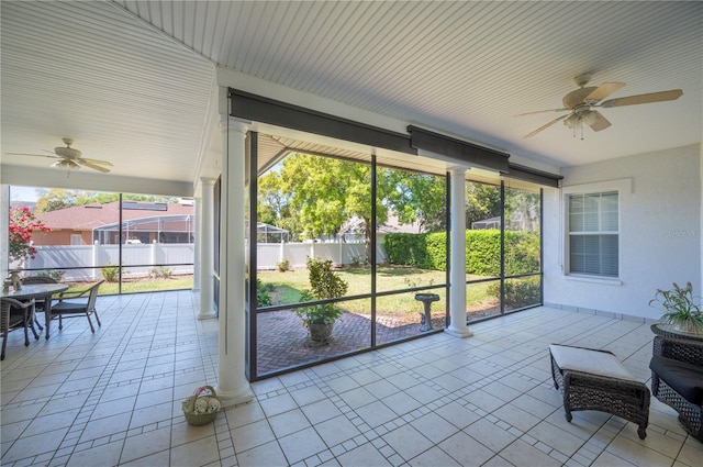 sunroom with ornate columns and a ceiling fan