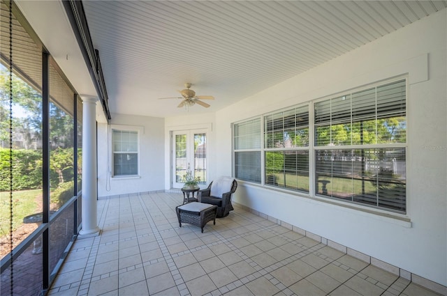 unfurnished sunroom with ornate columns and a ceiling fan