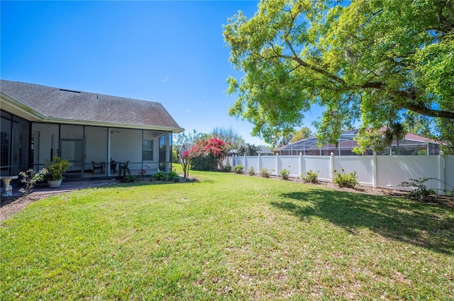 view of yard featuring a sunroom and a fenced backyard