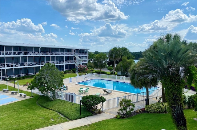 community pool featuring a yard, a patio area, and fence