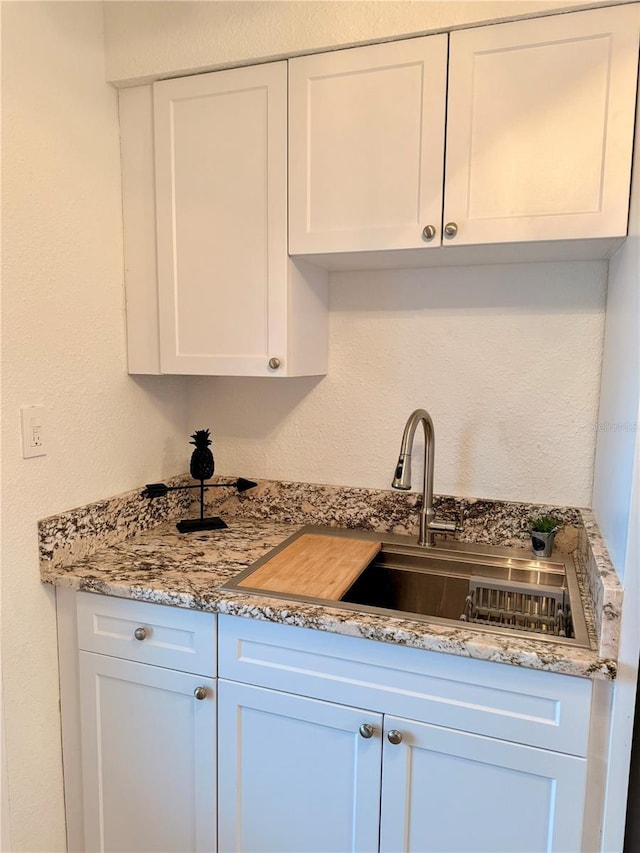 kitchen featuring a sink and white cabinets