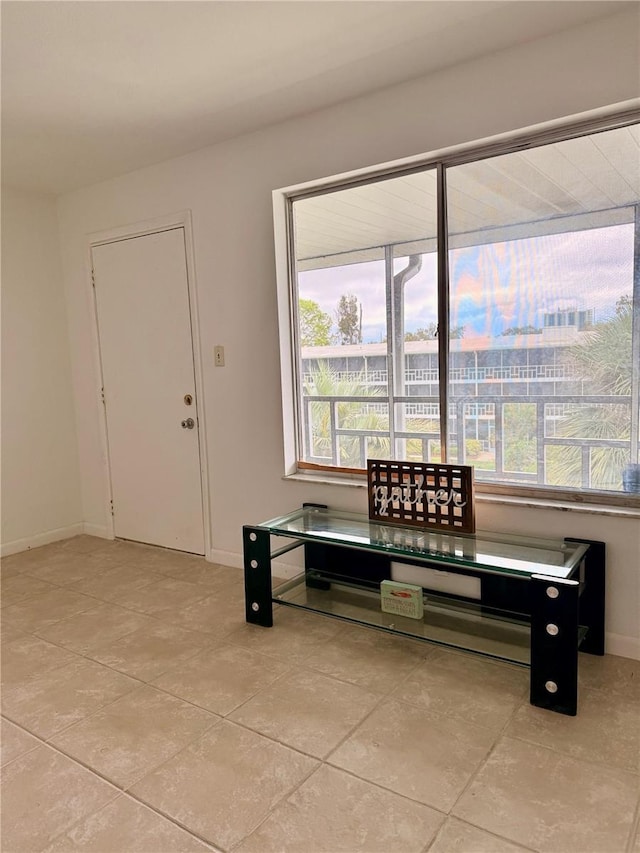 interior space with light tile patterned floors and baseboards