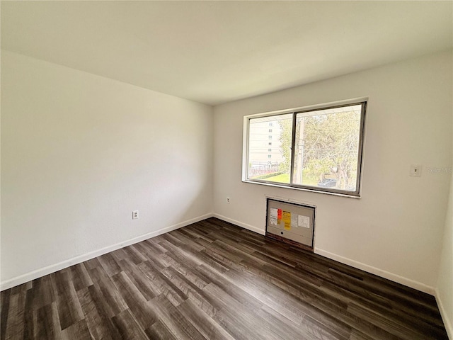 empty room with dark wood-style floors and baseboards