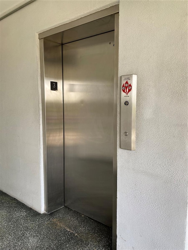 room details featuring speckled floor and elevator