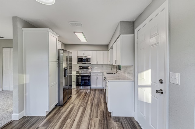 kitchen featuring light countertops, visible vents, backsplash, appliances with stainless steel finishes, and white cabinetry