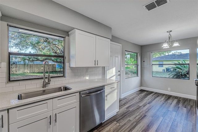 kitchen featuring pendant lighting, backsplash, stainless steel dishwasher, white cabinetry, and a sink