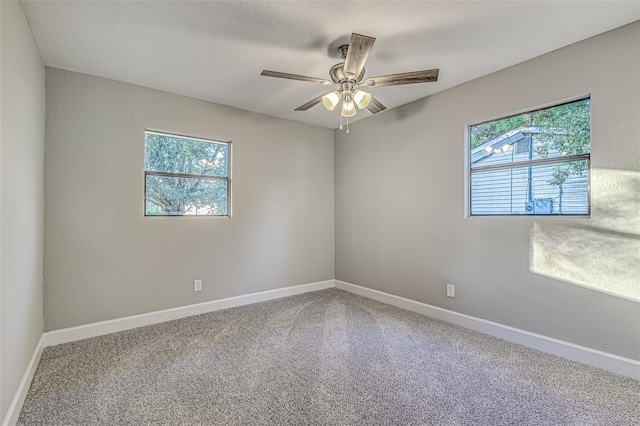 carpeted empty room with ceiling fan, a textured ceiling, and baseboards