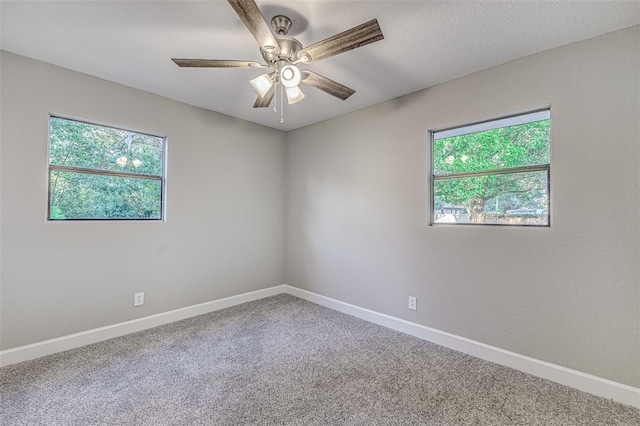 spare room with a textured ceiling, carpet flooring, a ceiling fan, and baseboards