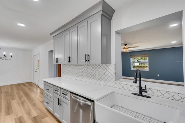 kitchen featuring a sink, ornamental molding, stainless steel dishwasher, backsplash, and light wood finished floors