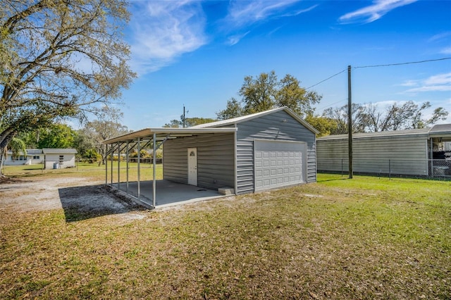 garage featuring a garage, driveway, and fence