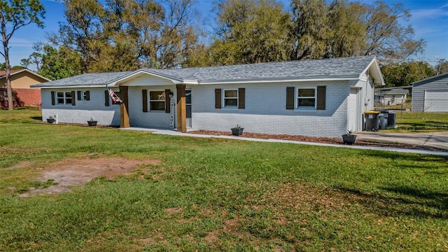 single story home featuring a front yard and brick siding