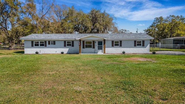 ranch-style home with brick siding, fence, and a front yard