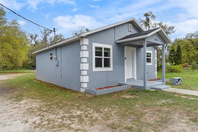 exterior space with a front yard and stucco siding