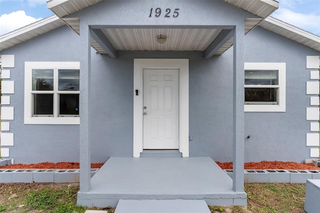 view of exterior entry with stucco siding