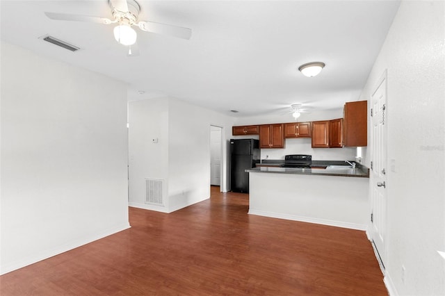 kitchen with dark countertops, visible vents, dark wood finished floors, and black appliances