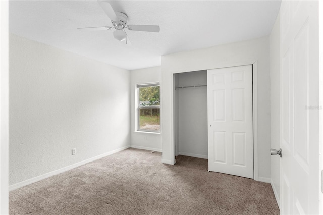 unfurnished bedroom with carpet, baseboards, ceiling fan, and a closet