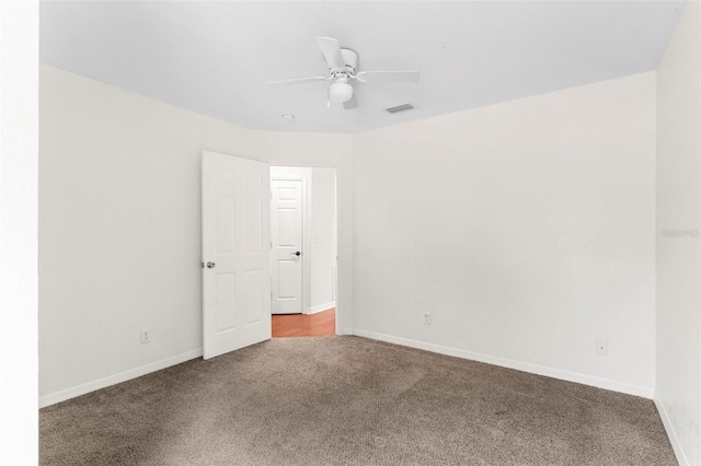 spare room with ceiling fan, carpet floors, visible vents, and baseboards