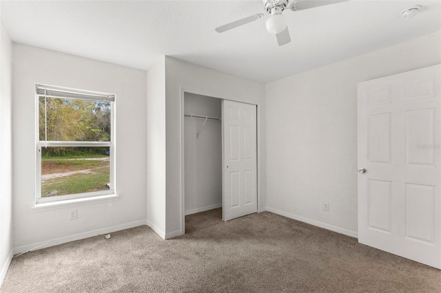 unfurnished bedroom featuring a ceiling fan, a closet, carpet flooring, and baseboards