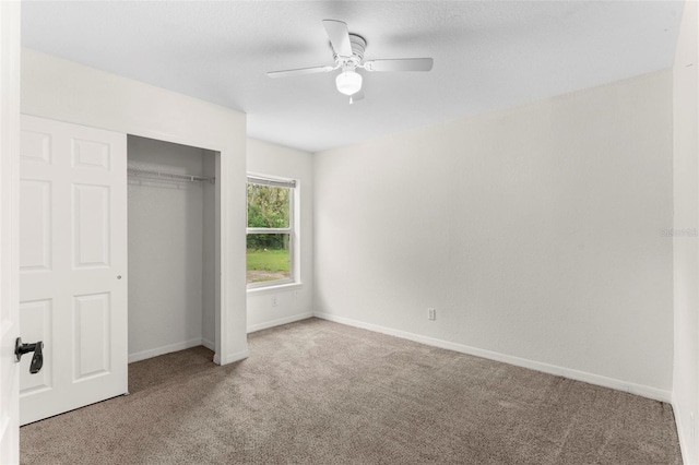 unfurnished bedroom featuring a closet, carpet flooring, a ceiling fan, and baseboards