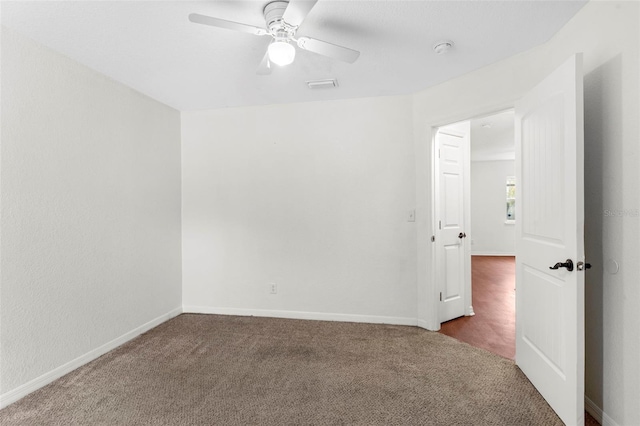 spare room with carpet, visible vents, ceiling fan, and baseboards