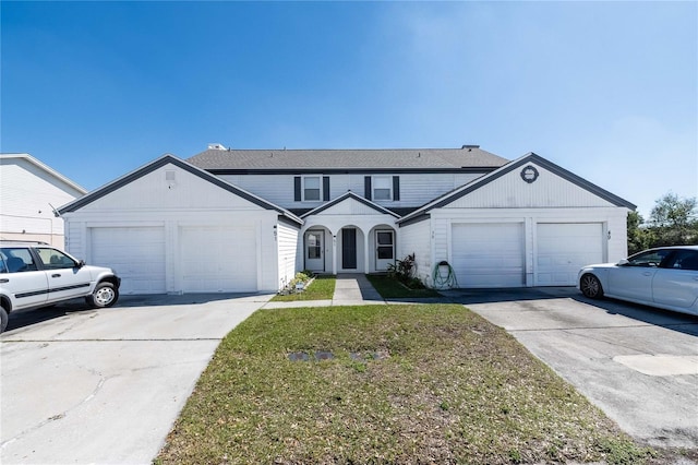 traditional-style home featuring an attached garage, concrete driveway, and a front yard