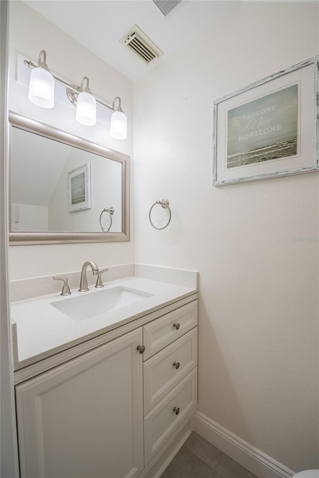 bathroom with vanity, visible vents, and baseboards